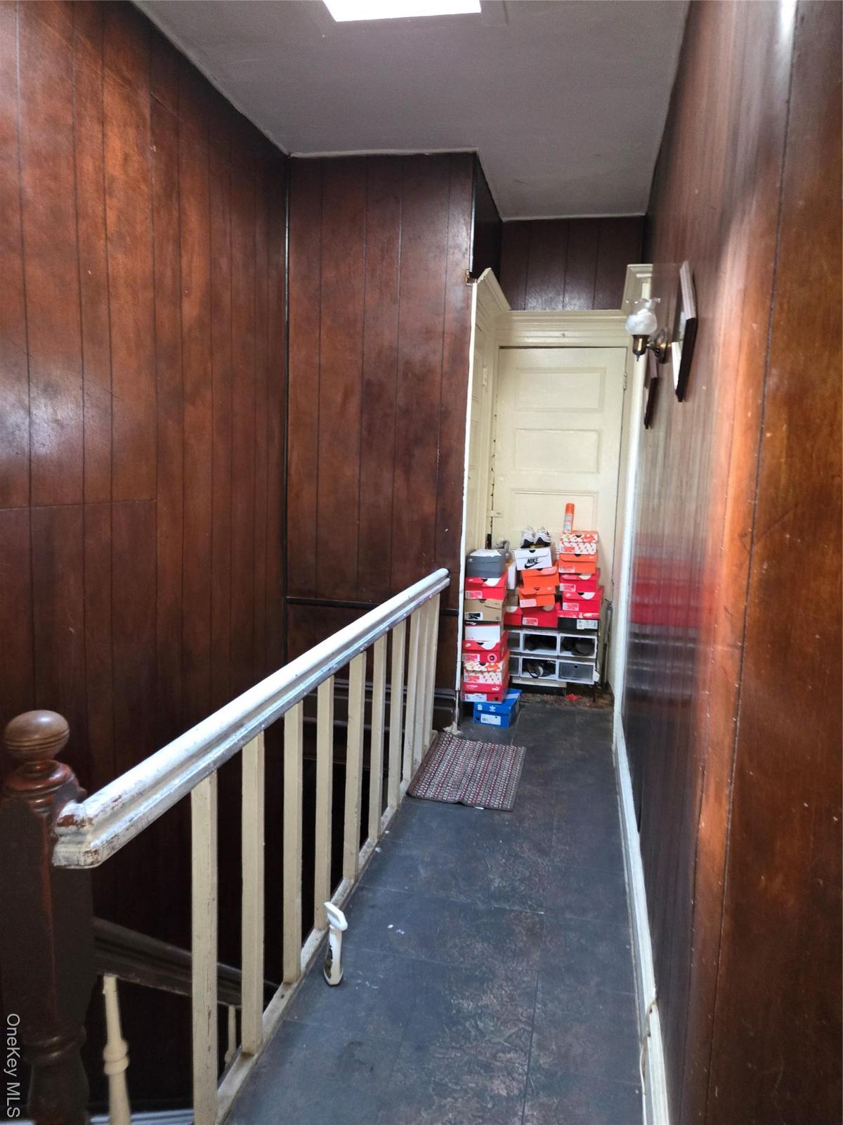 Hallway featuring wood walls