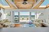 Open-concept room featuring wood-finish flooring, a natural wood paneled ceiling with exposed beams, multiple skylights, and a ceiling fan