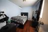 Bedroom with wood finished floors and an AC wall unit