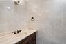 Bathroom vanity featuring a light-toned stone countertop with an integrated oval sink and bronze-finish fixtures