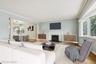 Living area featuring wood finished floors, a fireplace, and crown molding