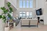 Living area with fireplace, a towering ceiling, and tile flooring