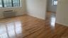 Empty room featuring light wood-style floors and a wall mounted air conditioner