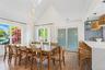 Dining area with high vaulted ceiling, light wood-style flooring, and plenty of natural light