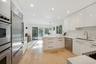 Kitchen featuring sink, kitchen peninsula, pendant lighting, white cabinets, and appliances with stainless steel finishes