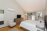 Bedroom featuring an AC wall unit, light wood finished floors, access to outside, high vaulted ceiling, and a baseboard heating unit