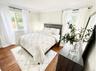 Bedroom with multiple windows, wood finished floors, and ornamental molding