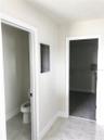 Master Bathroom toilet room and leading into master closet