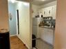 Kitchen with wood finished floors, a sink, baseboards, white cabinets, and freestanding refrigerator