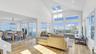 Living room with high vaulted ceiling, a skylight, light wood finished floors, and recessed lighting