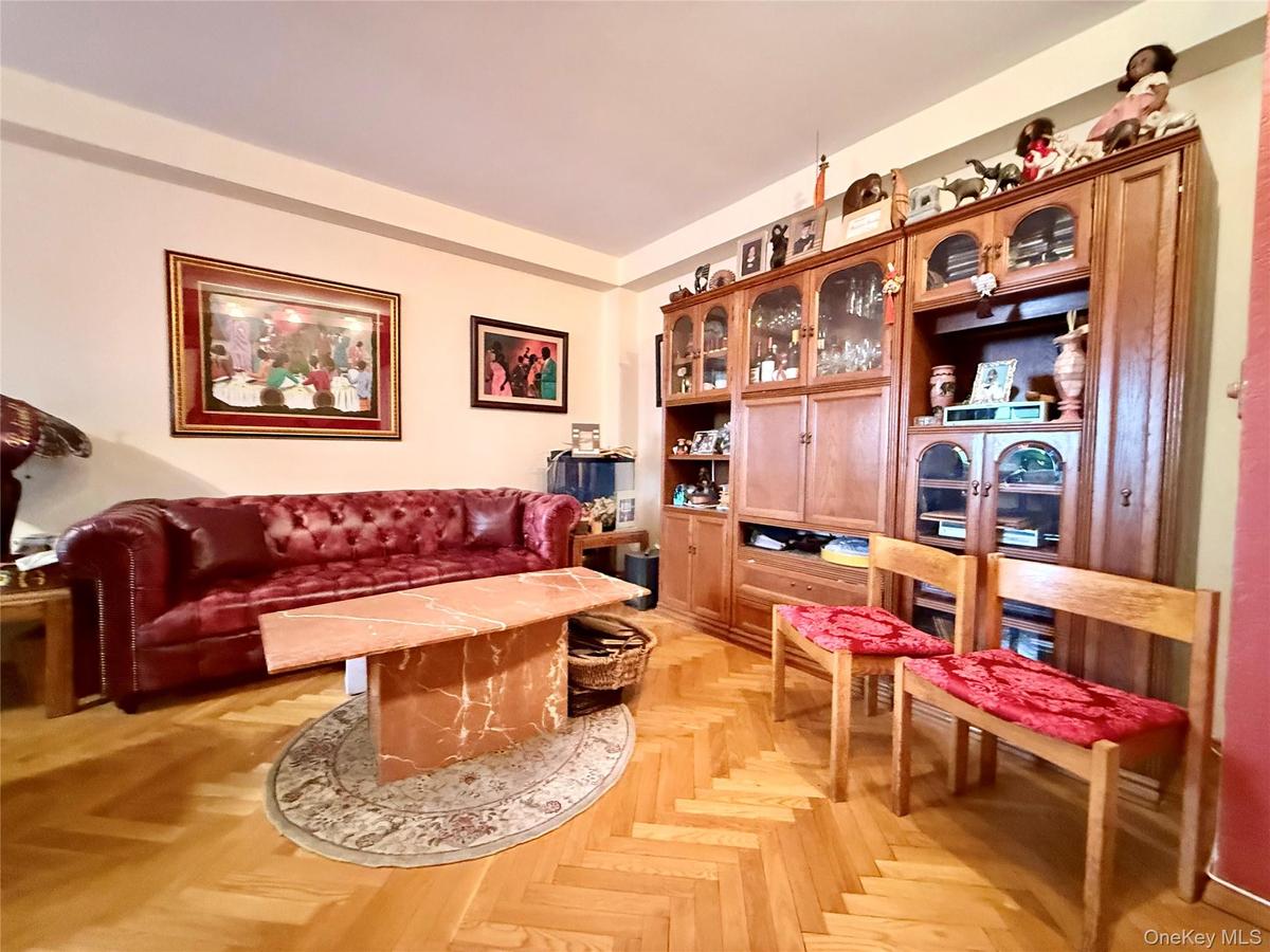 Elegant herringbone hardwood floors, open to the dining area that has a double panel window