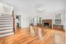 Large living room with wood burning fireplace, 3 windows allowing generous natural light, Hardwood flooring.