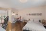 Bedroom with an office area, dark wood finished floors, a chandelier, and ensuite bathroom