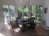 Sunroom featuring wood-type flooring, a wooden deck, wooden walls, and plenty of natural light