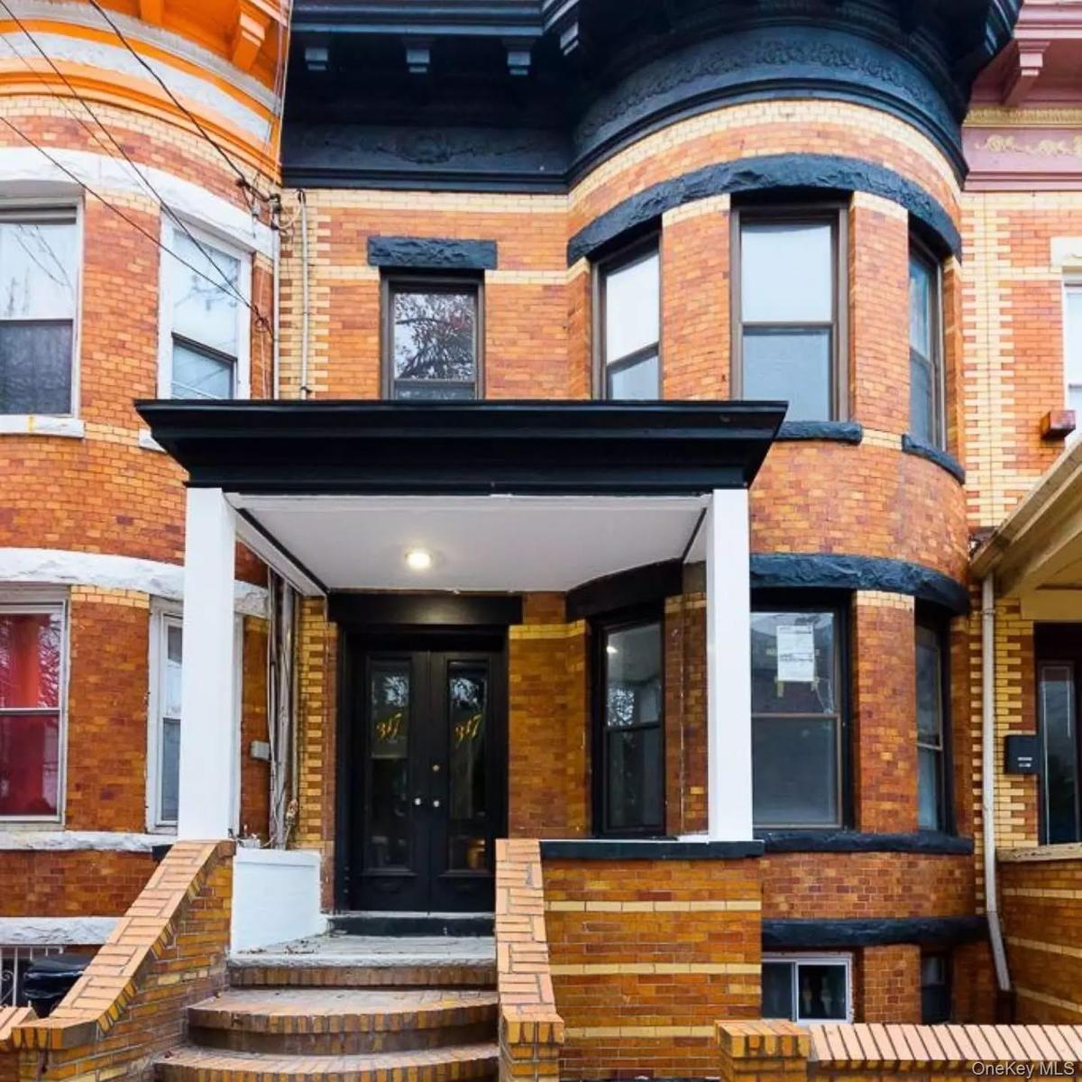 Doorway to property with brick siding, a porch, and french doors