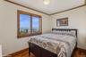 Bedroom with ornamental molding, a water view, and wood-type flooring