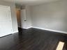Spare room with baseboards and dark wood-style flooring