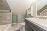 Upstairs a1Bathroom featuring vanity, lofted ceiling, tile patterned flooring, and toilet