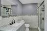 Bathroom featuring a stall shower, vanity, tile walls, and light tile patterned floors