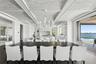 Kitchen featuring a center island with sink, wood finished floors, a chandelier, and white cabinetry