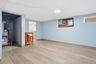 Finished room featuring wood-finish flooring, light blue painted walls, and a flush mount ceiling light
