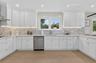Kitchen featuring white shaker cabinetry, stainless steel appliances, mosaic tile backsplash, light wood-finish flooring, and recessed lighting