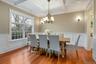 Dining room featuring coffered ceiling, crown molding, light hardwood / wood-style flooring, beamed ceiling, and a chandelier