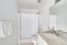 Bathroom with light tile patterned floors, vanity, and shower / bath combination with curtain
