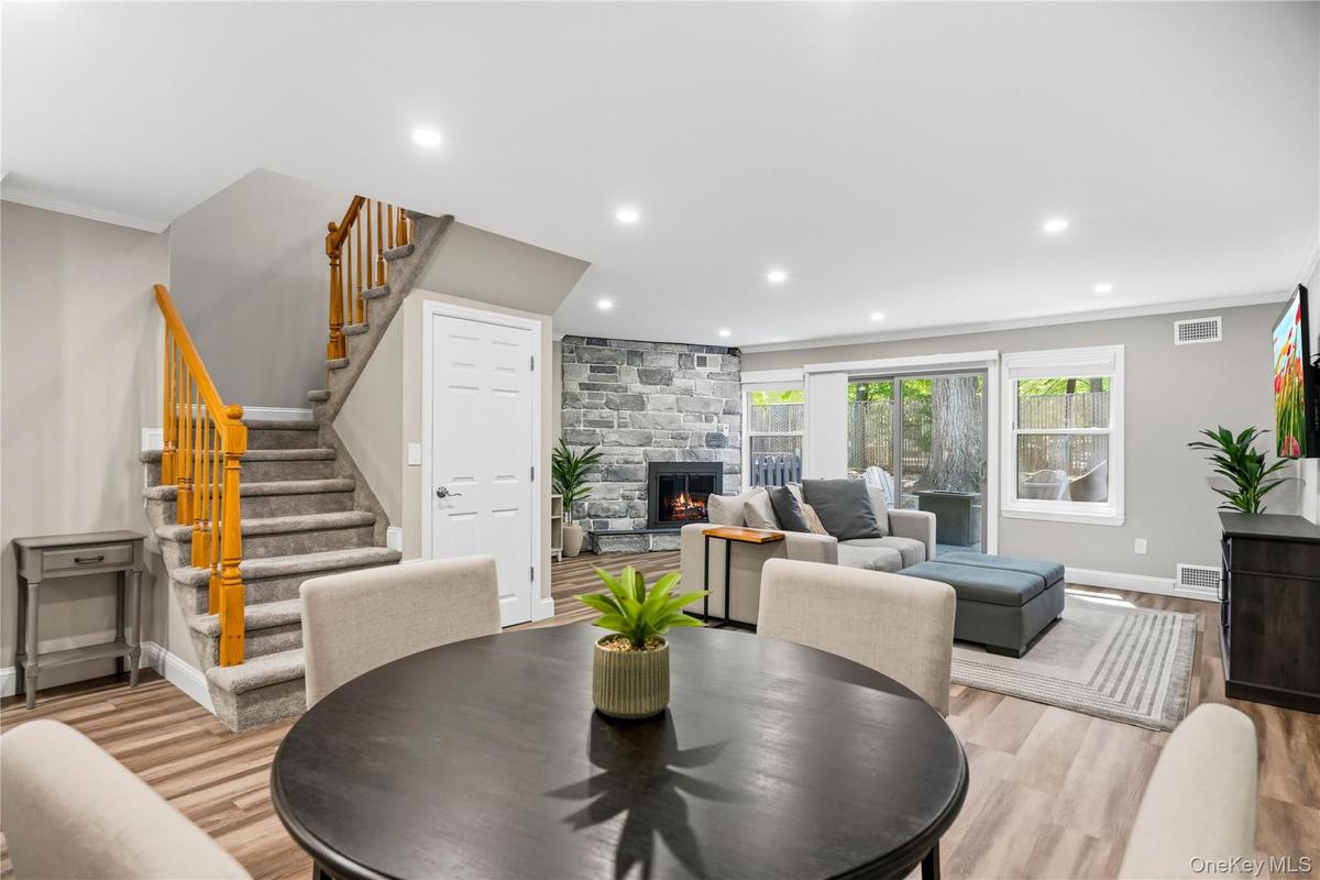 Open floor plan with dining room and living room with fireplace and sliders to new deck