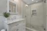 Bathroom featuring a shower stall, wainscoting, vanity, and recessed lighting