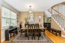 Dining area with a contemporary chandelier, large window with blinds