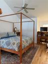 Bedroom with wood finished floors, vaulted ceiling, and a ceiling fan