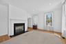 Tall ceilings, large windows, and a gas fireplace create a bright and inviting living area with plenty of room to relax.