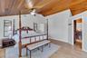 Bedroom with vaulted ceiling, light wood-type flooring, wooden ceiling, and a ceiling fan