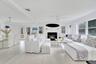 Living area with a glass covered fireplace, light wood-style floors, and ceiling fan