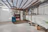Basement with oil tank, water heater, and a heating unit