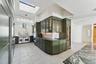 Kitchen featuring premium appliances, a skylight, extractor fan, and dark stone counters