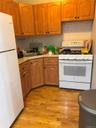 Kitchen featuring white appliances, a sink, light countertops, and light wood-style floors