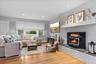 Living area featuring recessed lighting, wood finished floors, a brick fireplace, and baseboard heating
