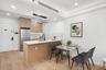 Kitchen featuring stainless steel refrigerator, a sink, light brown cabinetry, a peninsula, and light wood-type flooring