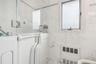 Full bath with marble finish floors, tile walls, washer / clothes dryer, heating unit, and a bath