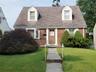 23-32 206th St Bayside.  Front view - wide line Cape Cod style home.