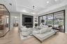 The great room is accented by wood beams, impressive chandeliers, gas fireplace, built-in cabinetry and oversized sliding glass doors that seamlessly 