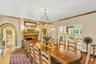 Dining space featuring ornamental molding, arched walkways, wood finished floors, and a lit fireplace