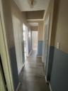 Hall featuring baseboards and dark wood-style flooring