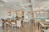Indoor wet bar with decorative light fixtures, beam ceiling, coffered ceiling, glass insert cabinets, and dark wood-type flooring