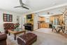 Open-concept living space with a kitchen featuring wood cabinetry, stainless steel appliances, and a tiled backsplash