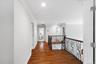 Hardwood flooring, crown molding, recessed lighting, white walls, and wrought iron railing overlooks great room