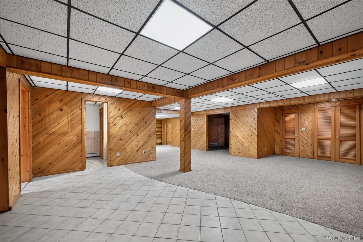 A finished lower level bonus space spanning approximately one thousand square feet, detailed with real wood wall planking, a full summer kitchen, and 