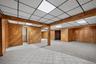 A finished lower level bonus space spanning approximately one thousand square feet, detailed with real wood wall planking, a full summer kitchen, and 